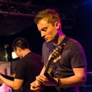 Photo of Wake Anderson playing the guitar in a live setting