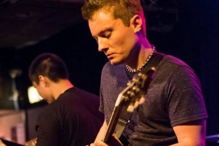 Photo of Wake Anderson playing the guitar in a live setting