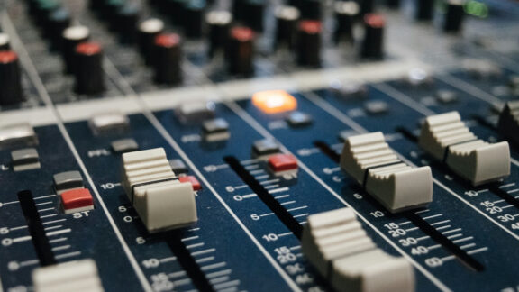 Photo of mixing console depicting audio stems